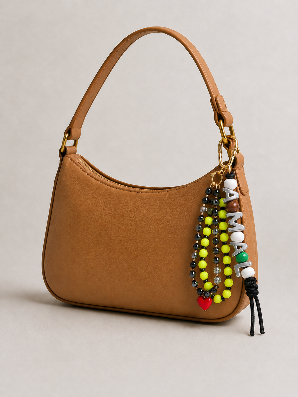 Personalised beaded name bag charm on tan leather shoulder bag